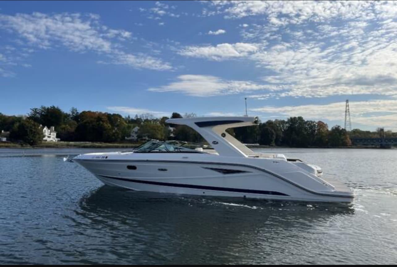 Starboard profile of Après Sea, a white Sea Ray SLX 310 with a sport arch, underway on the Mianus River.